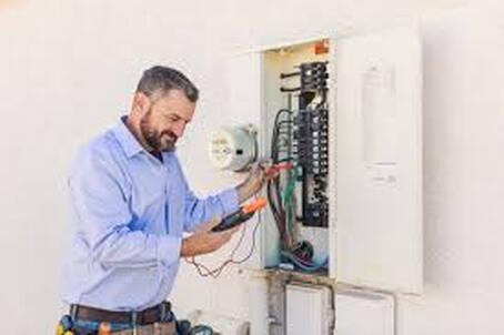 Electrician working on fuse box 