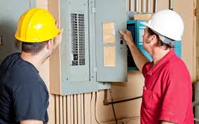 Electricians working on circuit box 